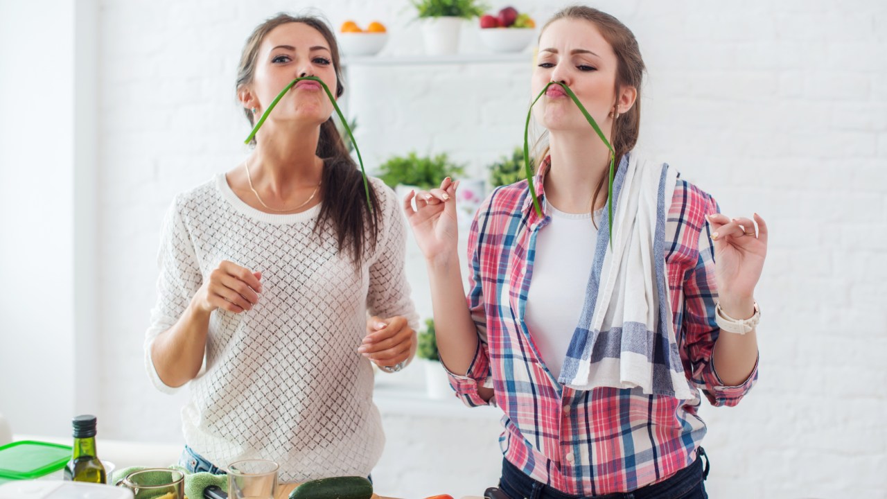 Amigas cozinhando e brincando com os ingredientes