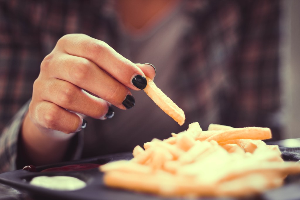 Mulher comendo batata frita