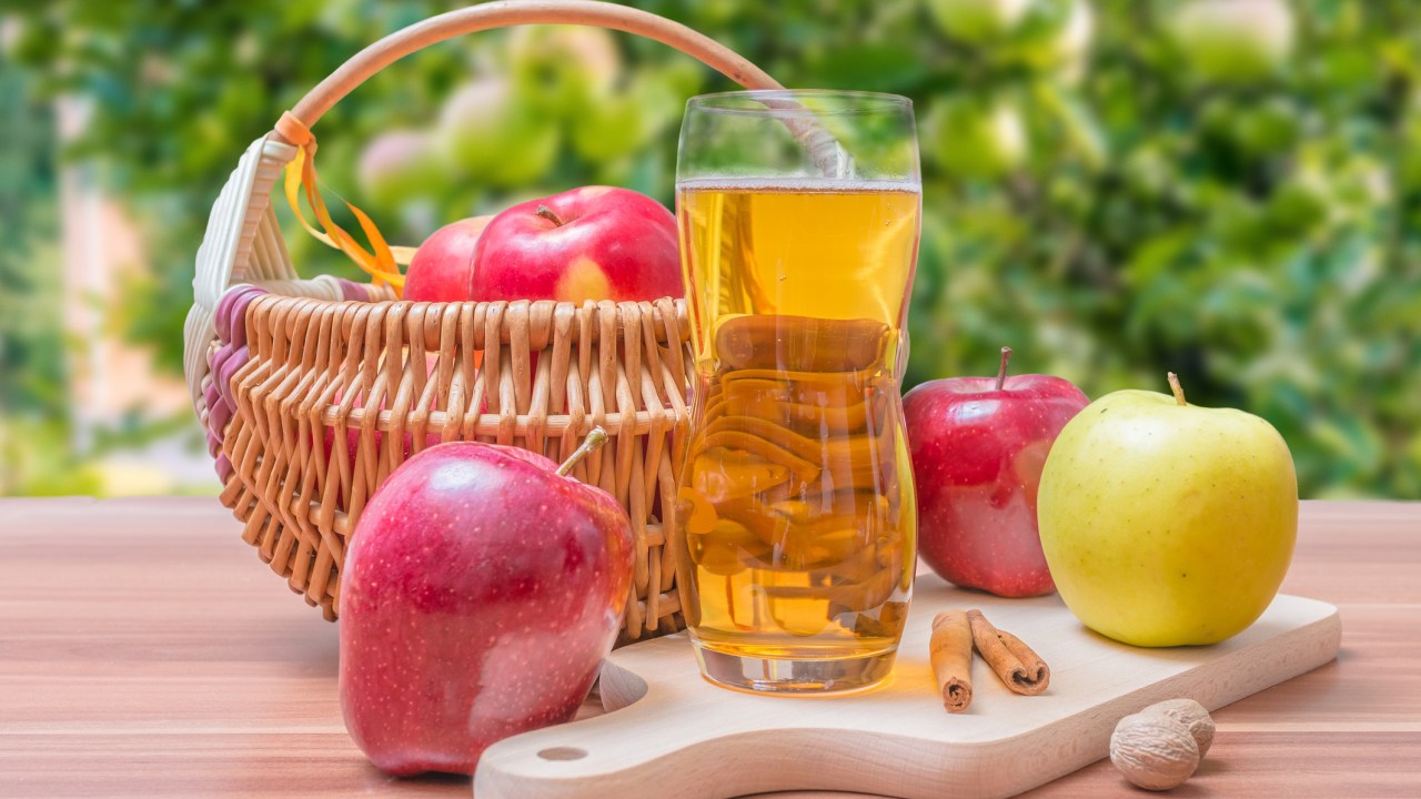 Cesta com vinagre de maça e frutas em bancada