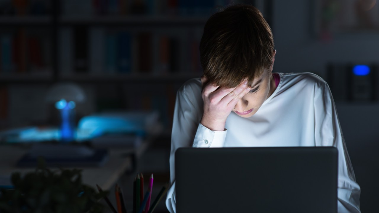 Mulher cansada trabalhando no computador até tarde