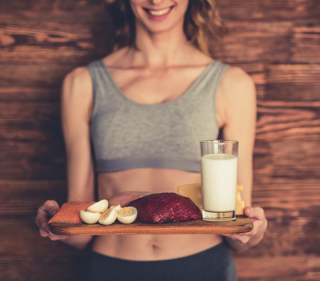 Mulher segurando alimentos proteicos