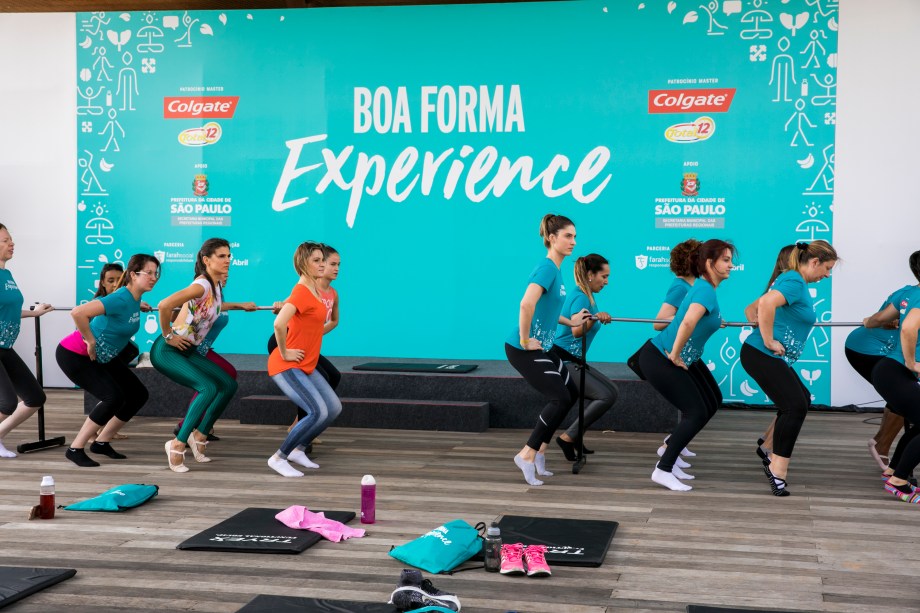 Mulherada caprichando na aula de balé fitness, em movimento inspirado no plié