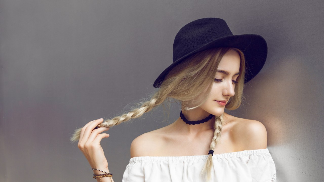 Mulher loira com tranças e chapéu