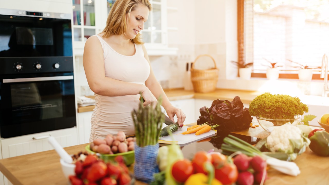 Mulher grávida cozinhando
