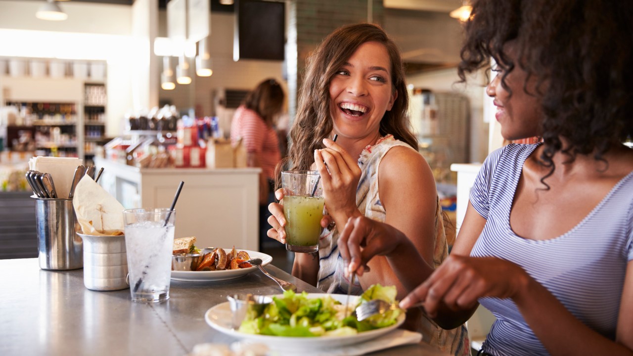 Duas amigas comendo no restaurante