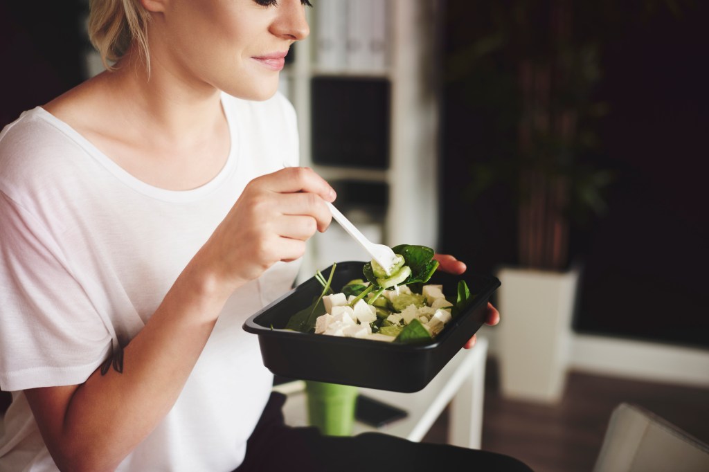 Mulher comendo salada