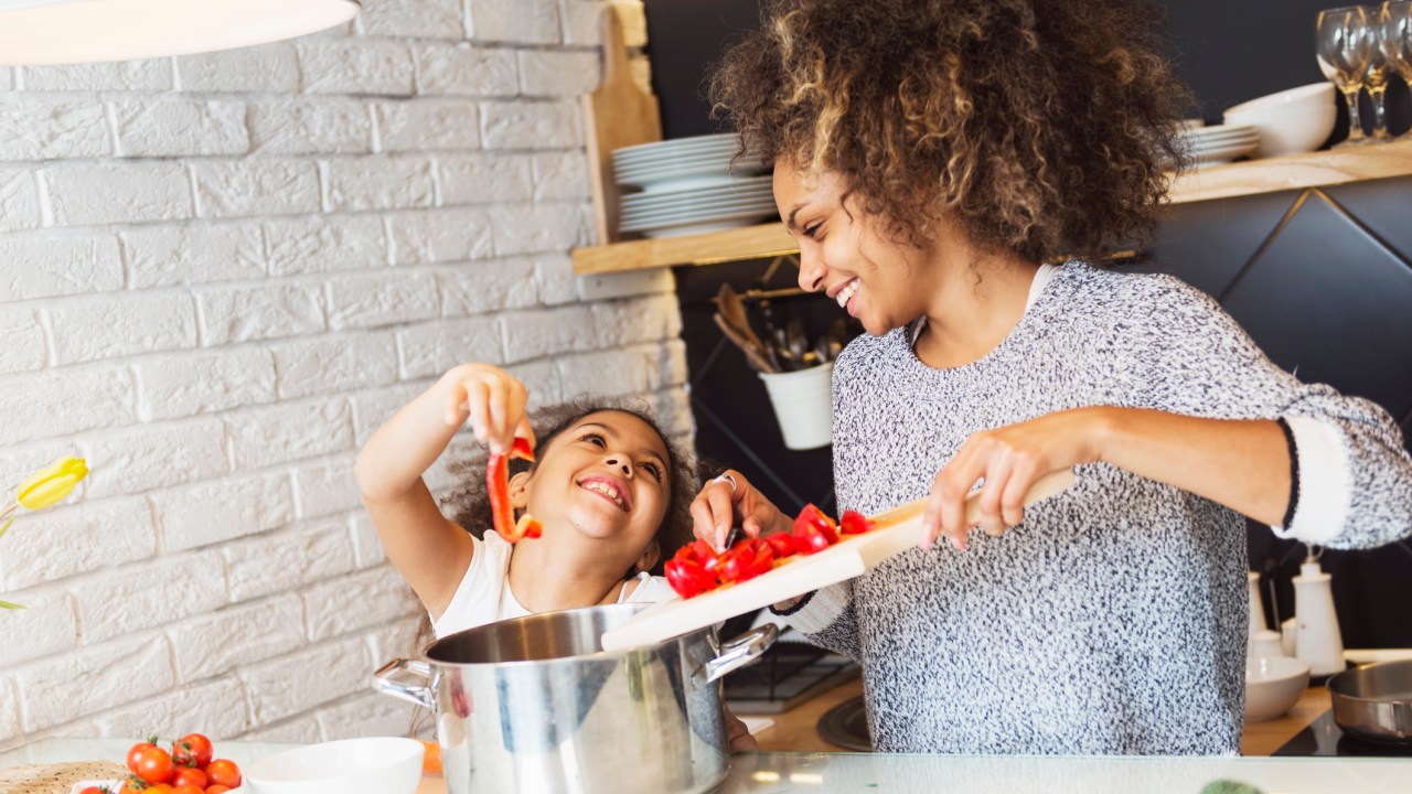 Mãe e criança cozinhando e felizes
