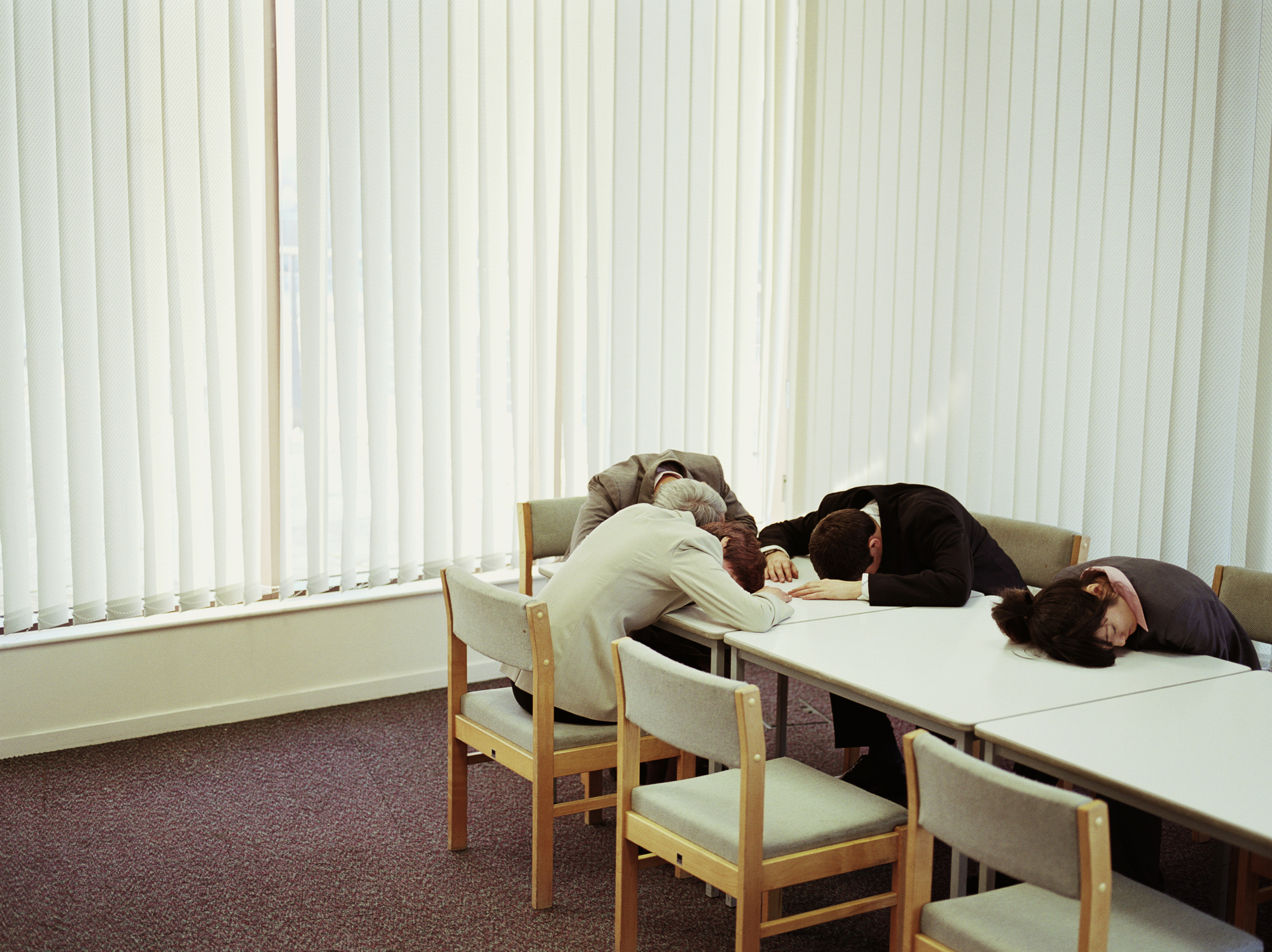 Group of business people with heads on conference table -