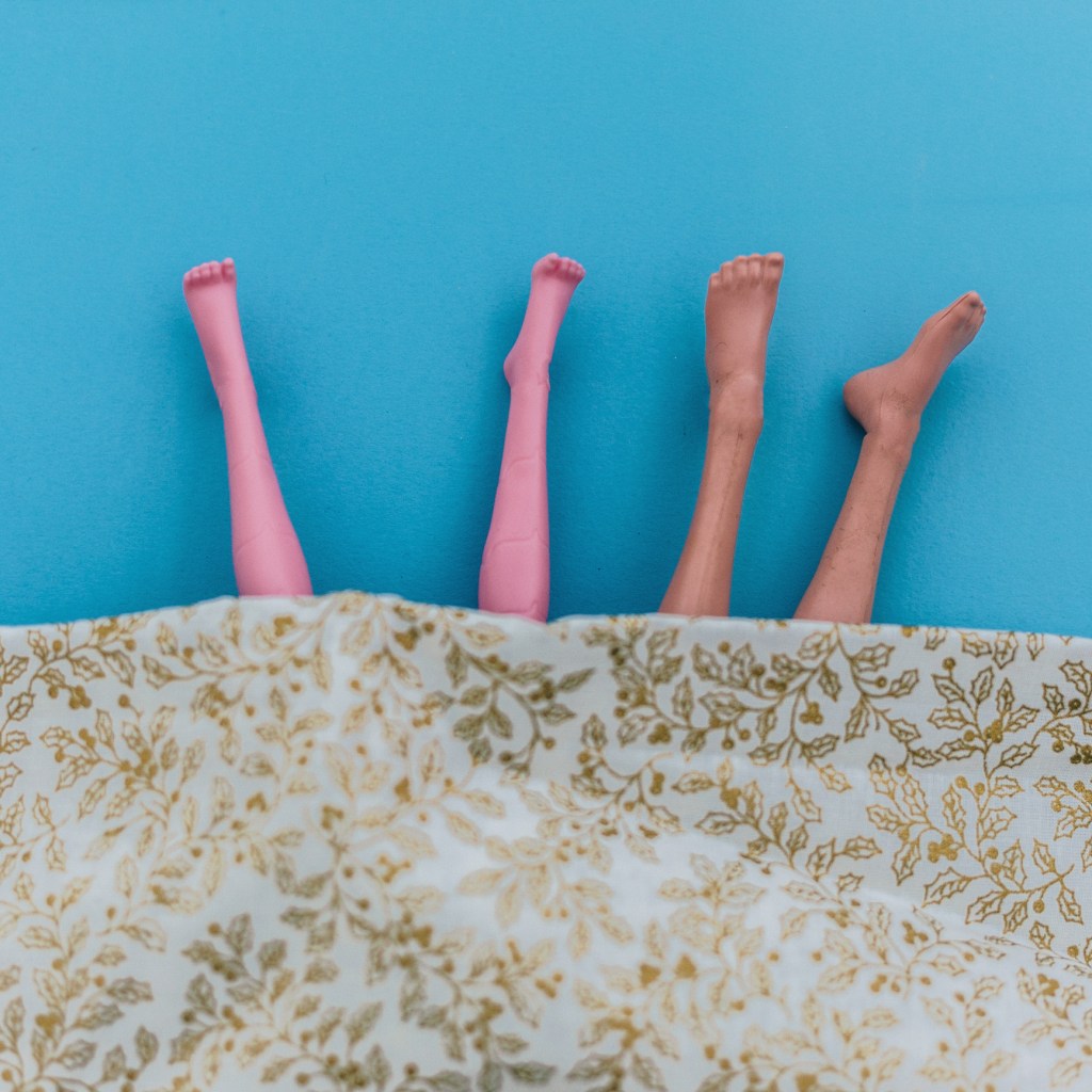 female and male doll legs in bed -