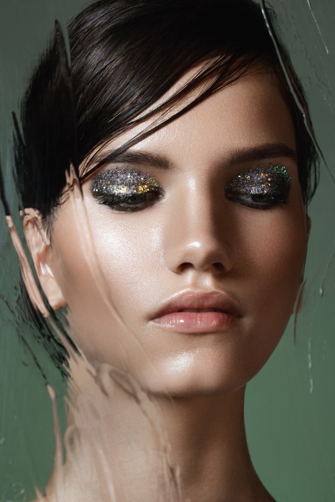 Beautiful woman behind wet glass -