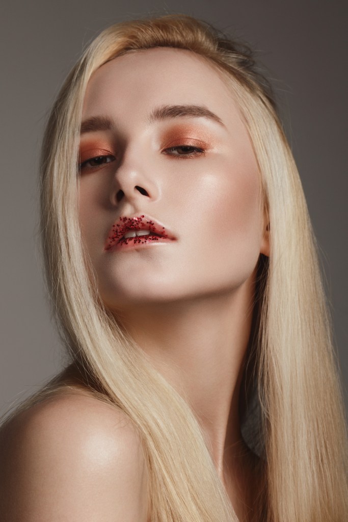 Beautiful natural blonde woman with glitter on her lips -