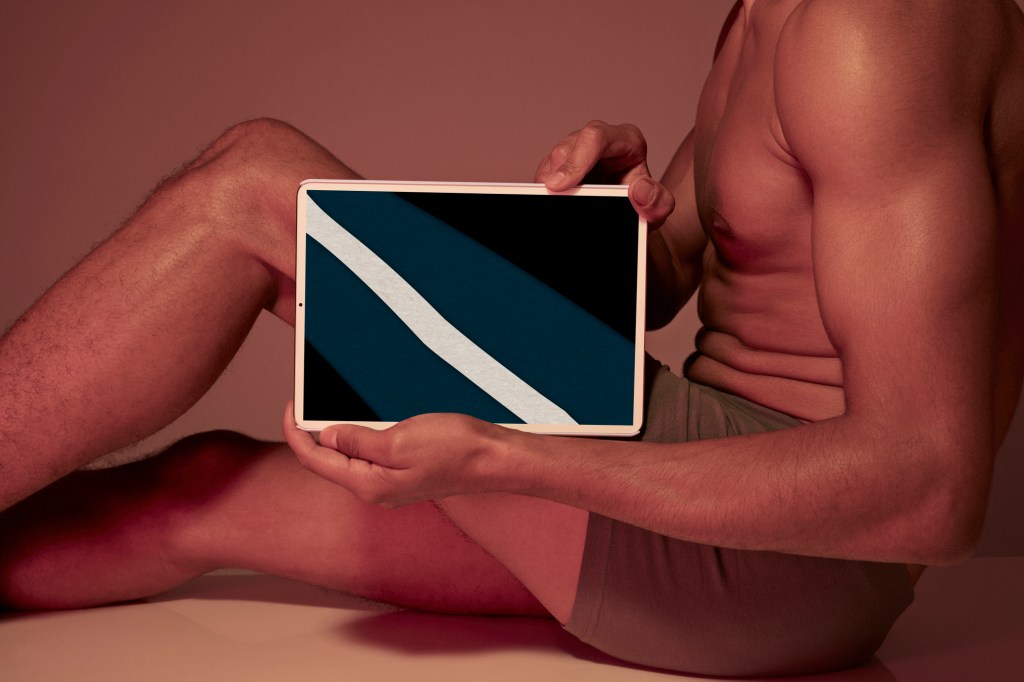 Young man holding tablet in front of body to show leg bone Perceber o espaço que cada tecido, incluindo cada osso, ocupa em seu corpo, é importante na Eutonia |