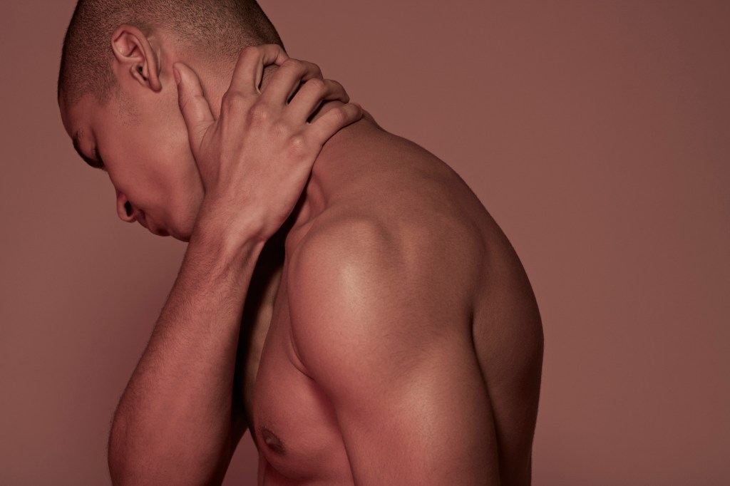Young man having neck pain Dores podem se instalar no seu corpo por fatores físicos ou mesmo emocionais |