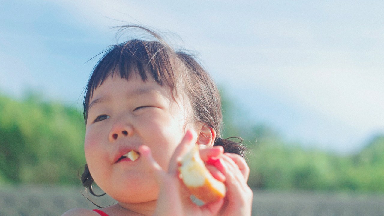 criança comendo pão