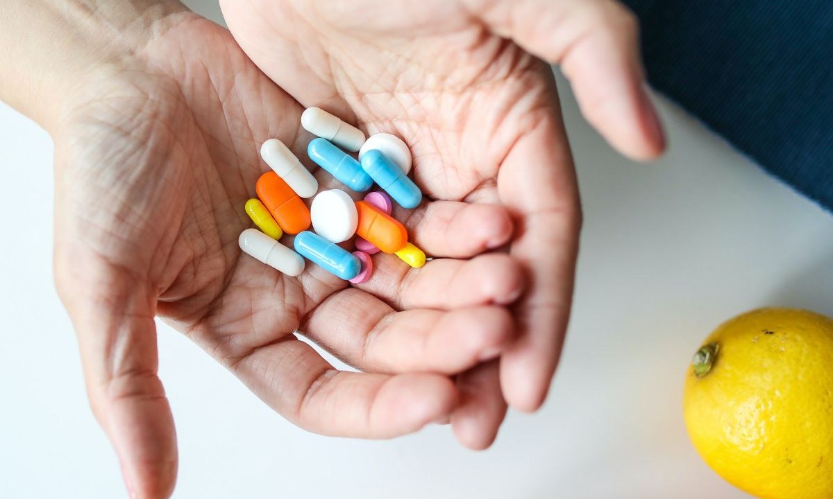 Mulher segurando vários medicamentos