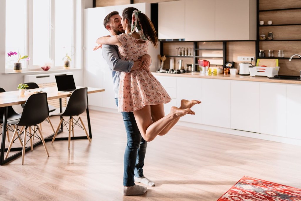 Casal dançando dentro de casa