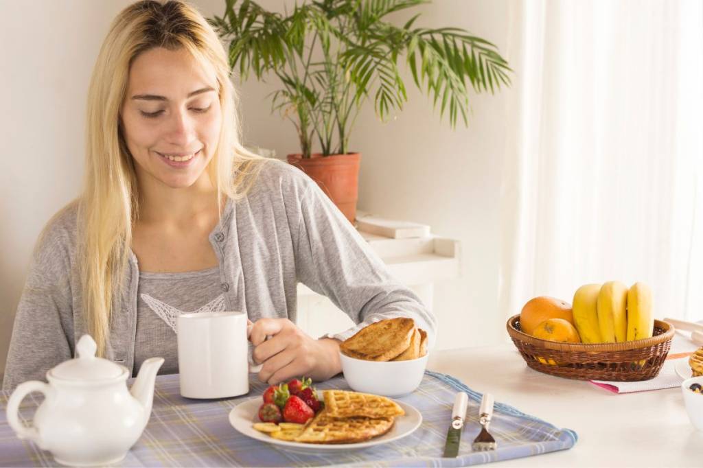 Mulher loira tomando café da manhã