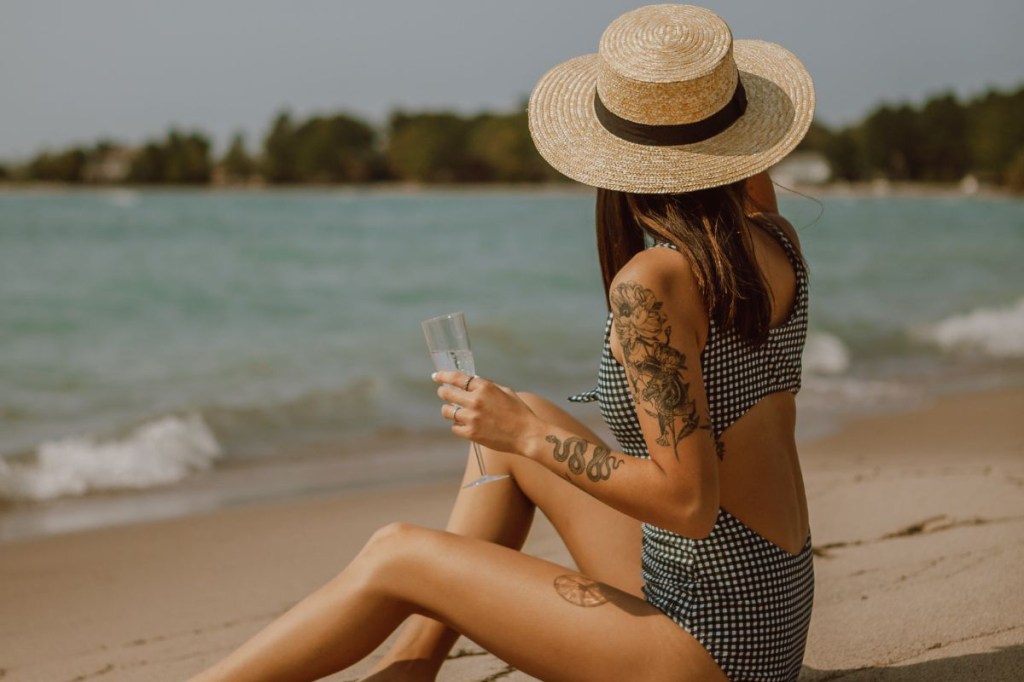 Mulher tatuada na beira da praia